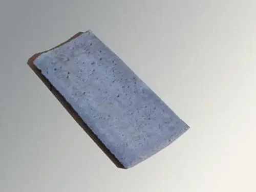 Grauer, flacher Zwischenstein aus einem Material, das für Feuerungsräume verwendet wird. Er gehört zur Produktpalette von Remeha.